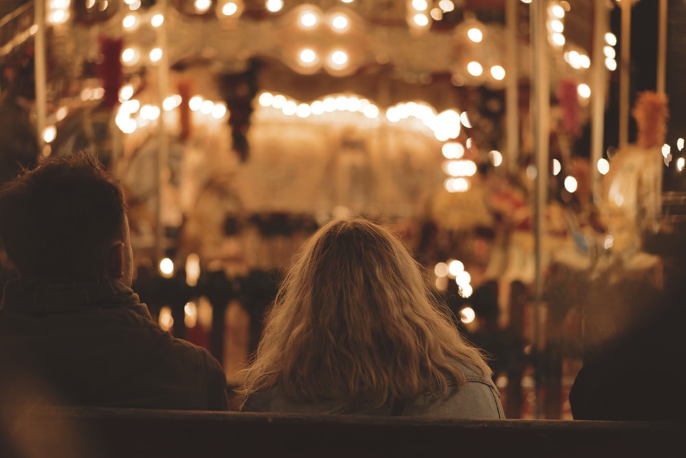 man and woman sitting on bench during nighttime