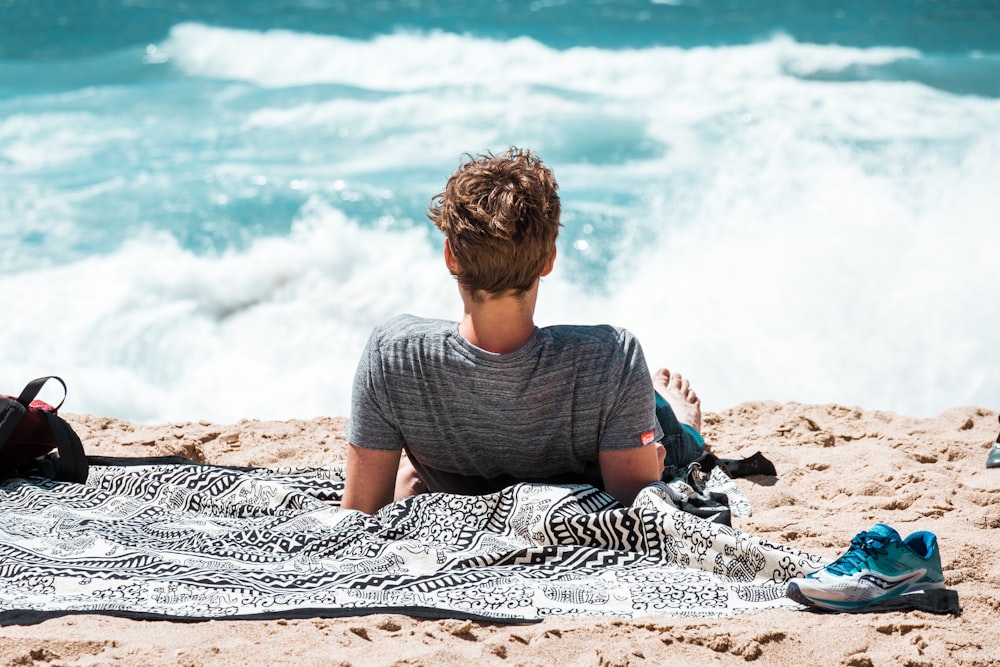 uomo sdraiato sulla riva del mare