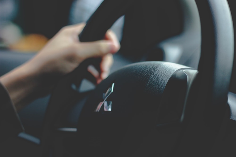 person holding Mitsubishi steering wheel