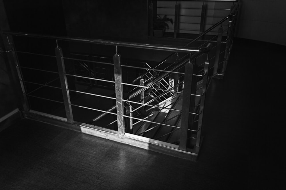 grayscale photo of stairs with steel rail