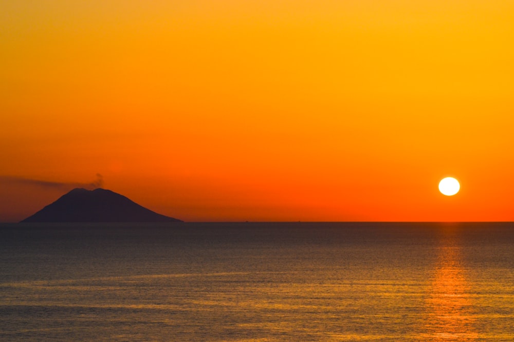 silhouette of mountain beside sea