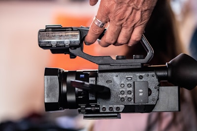 A close-up of a camera operator filming a community festival.