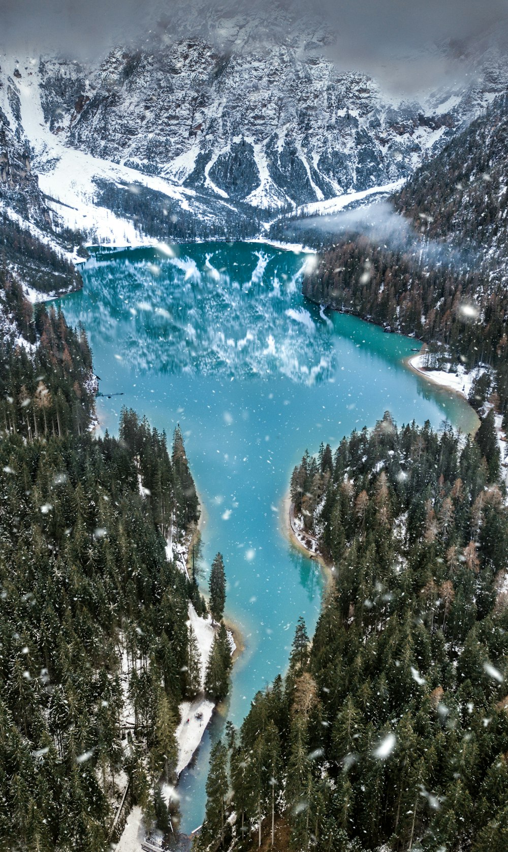 Luftaufnahme eines schneebedeckten Berges in der Nähe eines Gewässers