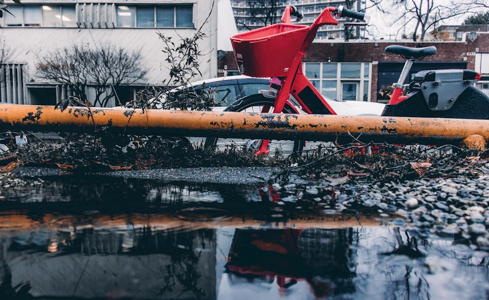 red and gray bicycle with basket parked outdoor