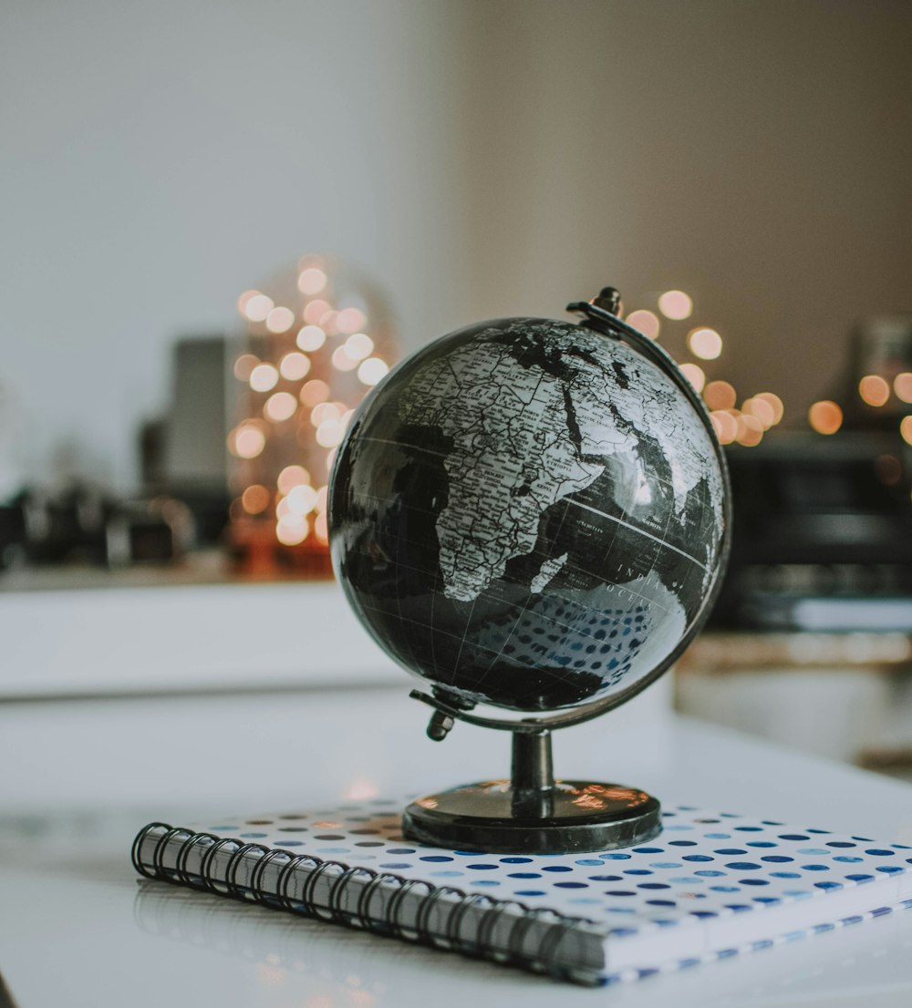 black and gray desk globe on notebook