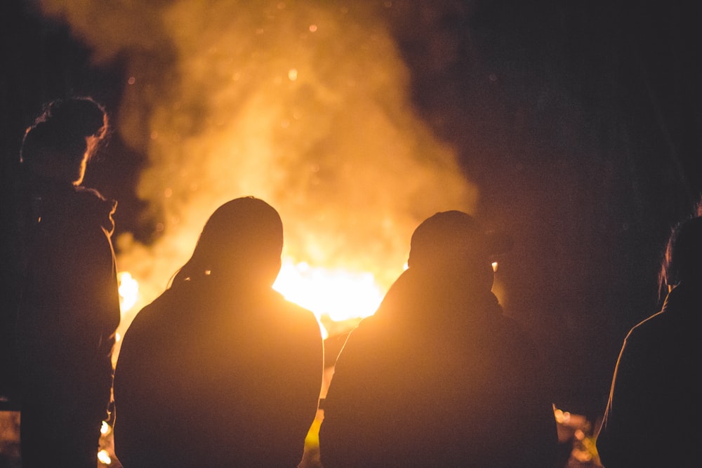 silhouette of four person front of fire