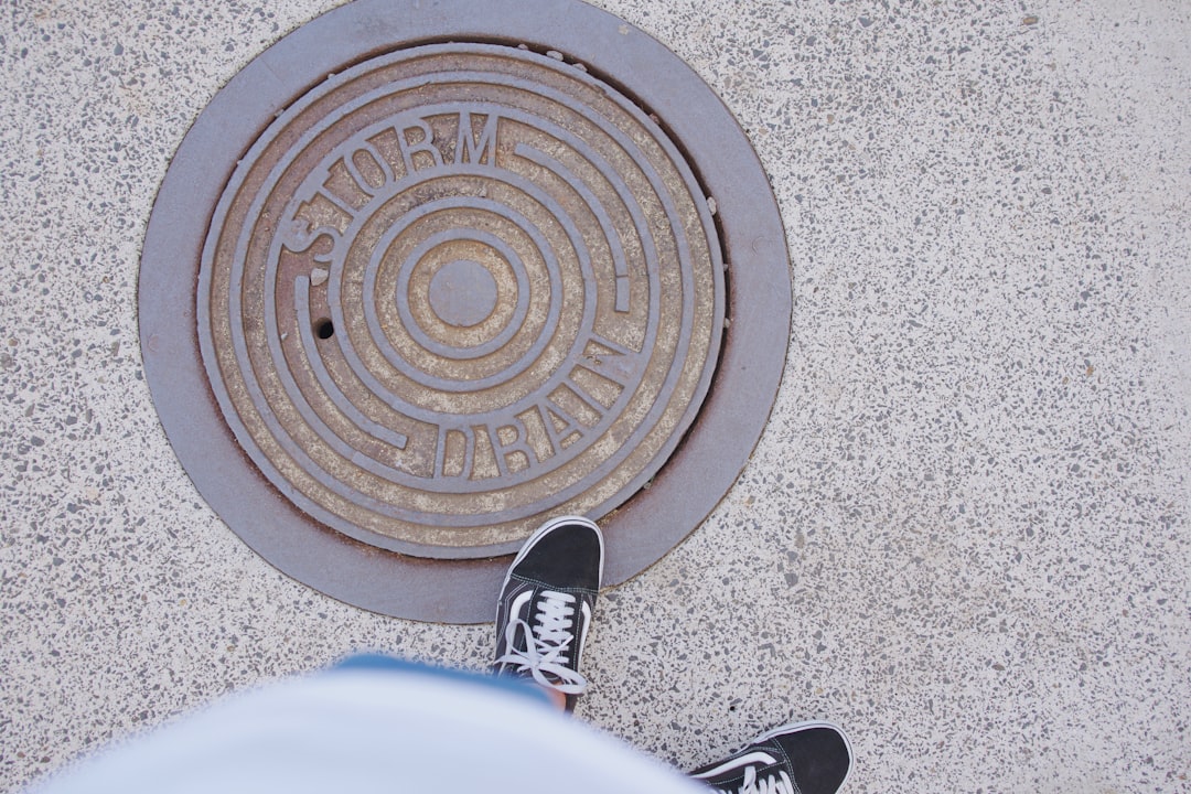 person standing next to manhole