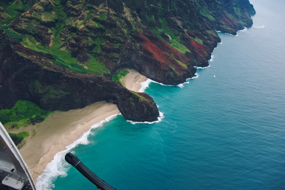 aerial photography of shore, cove and mountain