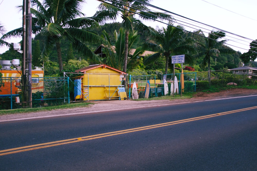 surfboards beside fence near the road during day