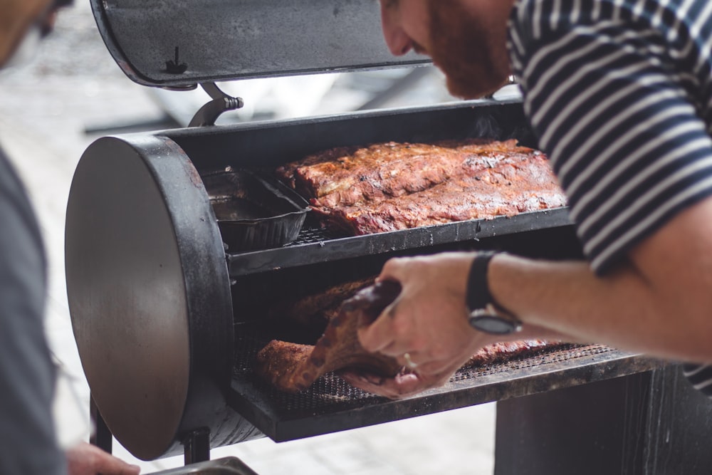 man grilling meat in smoker