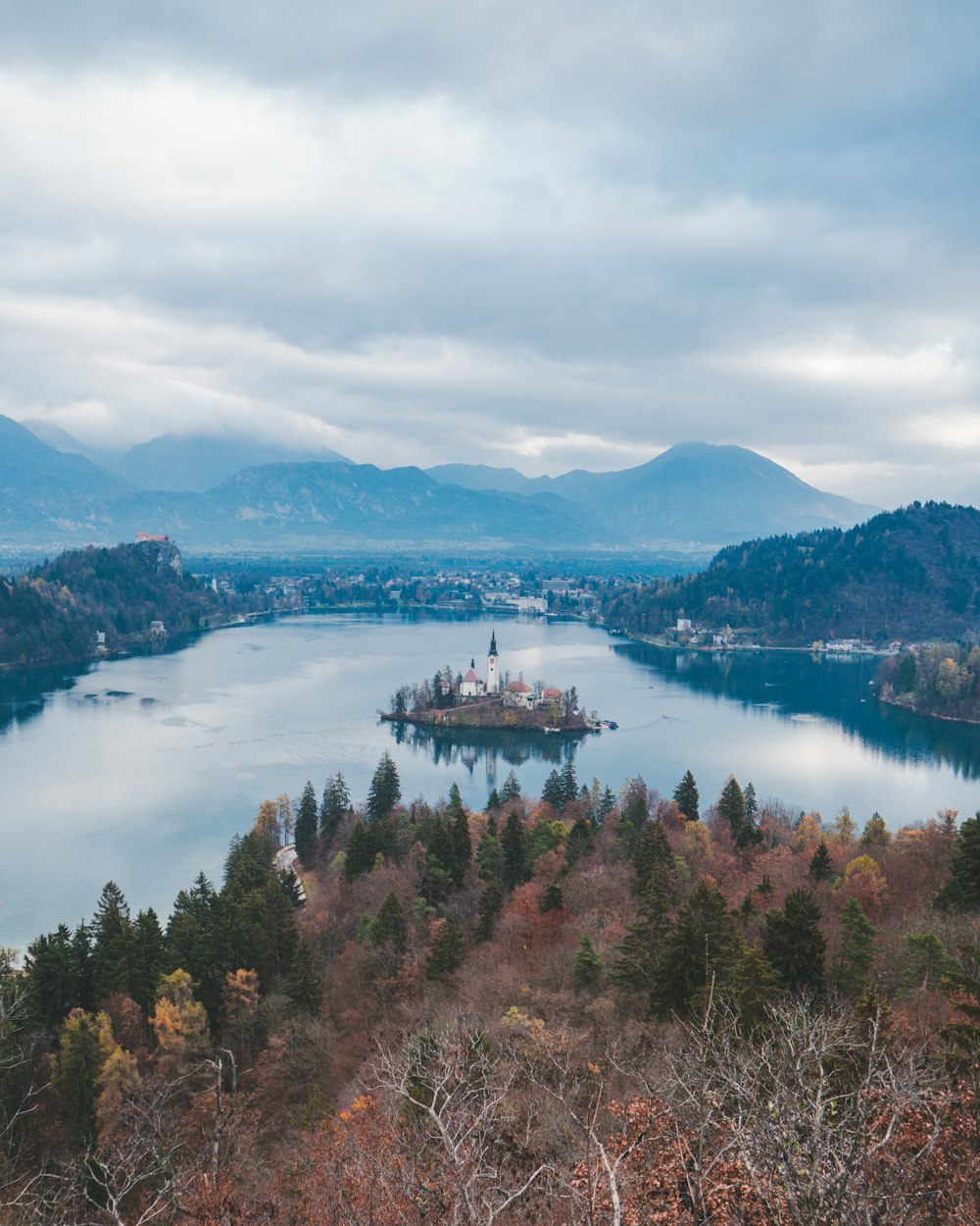 islet with house beside mountain during daytime