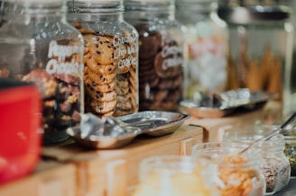 An assortment of elegantly presented cookie jars on a wooden table.