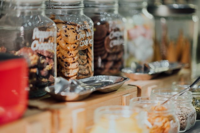 An assortment of elegantly presented cookie jars on a wooden table.