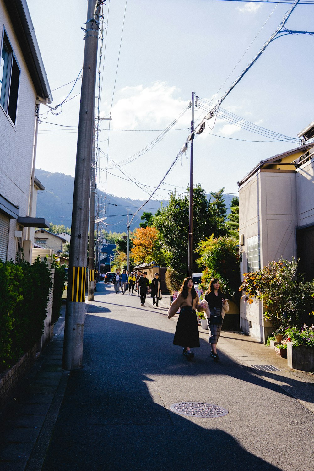 women walking on pathway between houses
