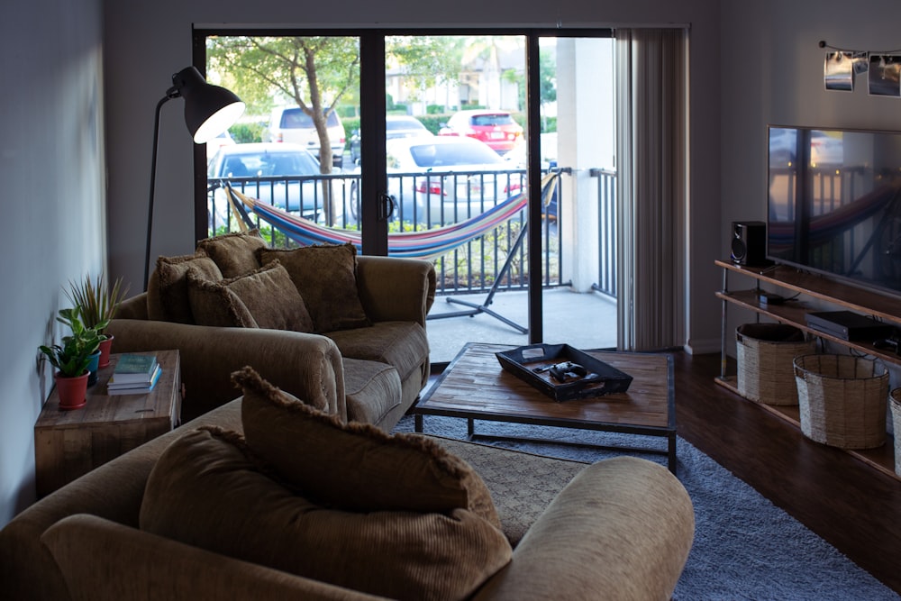 two brown sofa chairs beside glass window