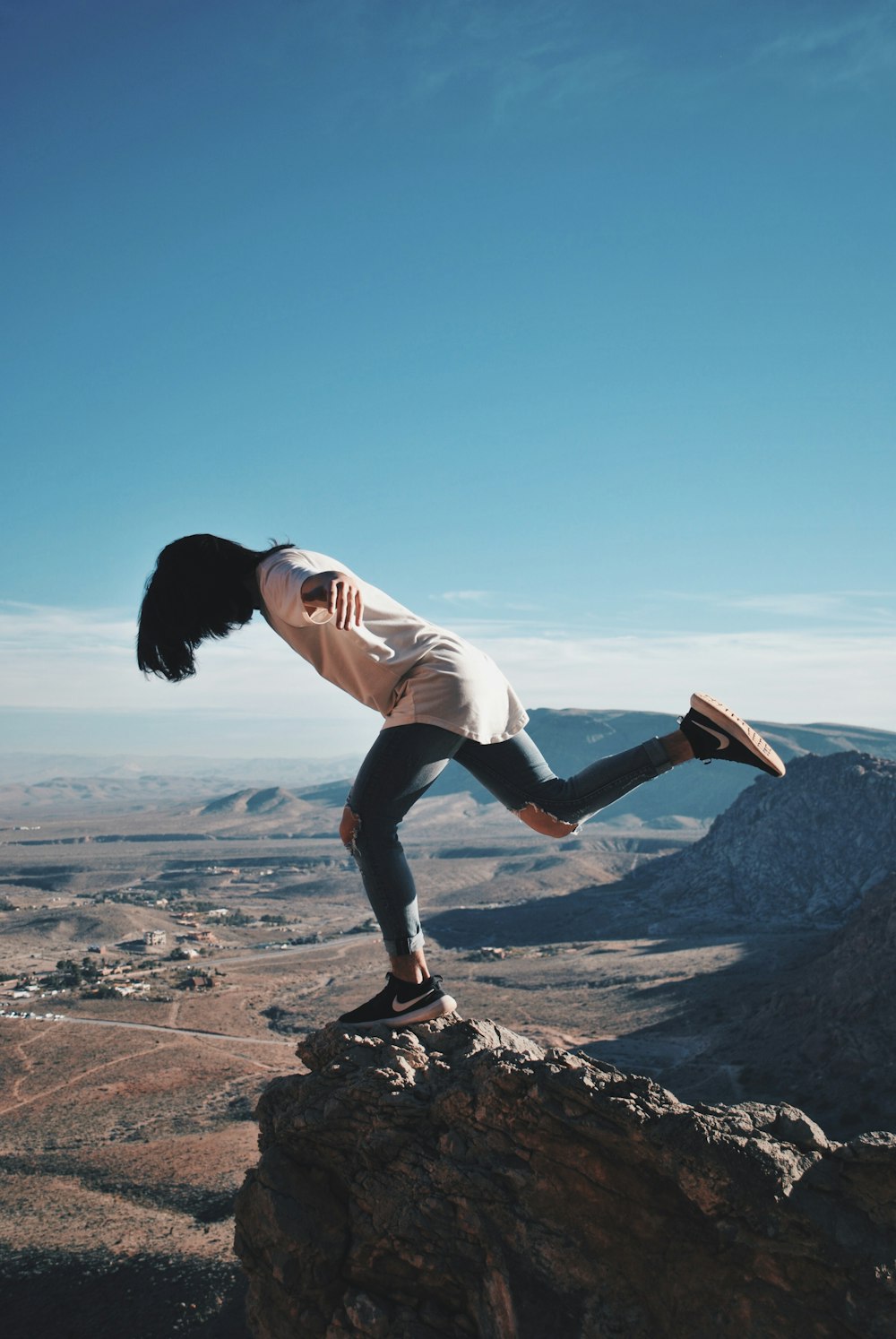 woman in stands on mountain edge