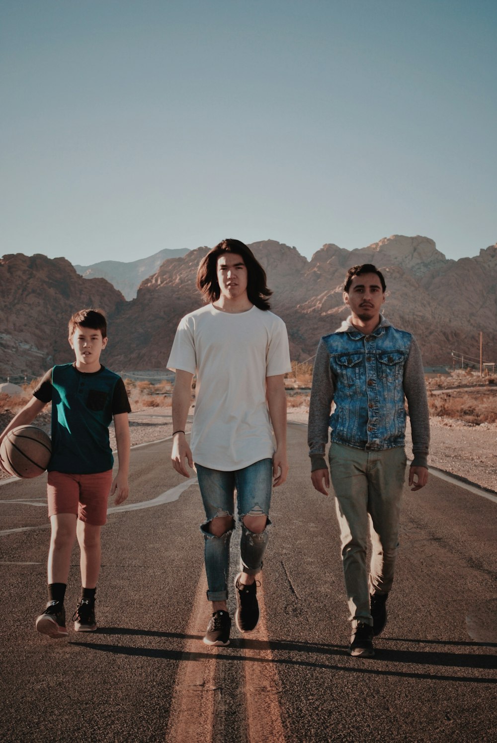 boy and men walking on concrete road