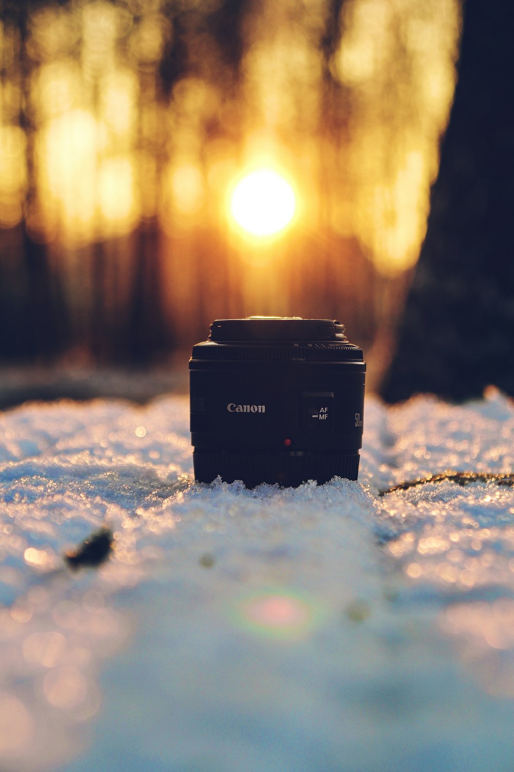 black Canon DSLR camera lens on snow