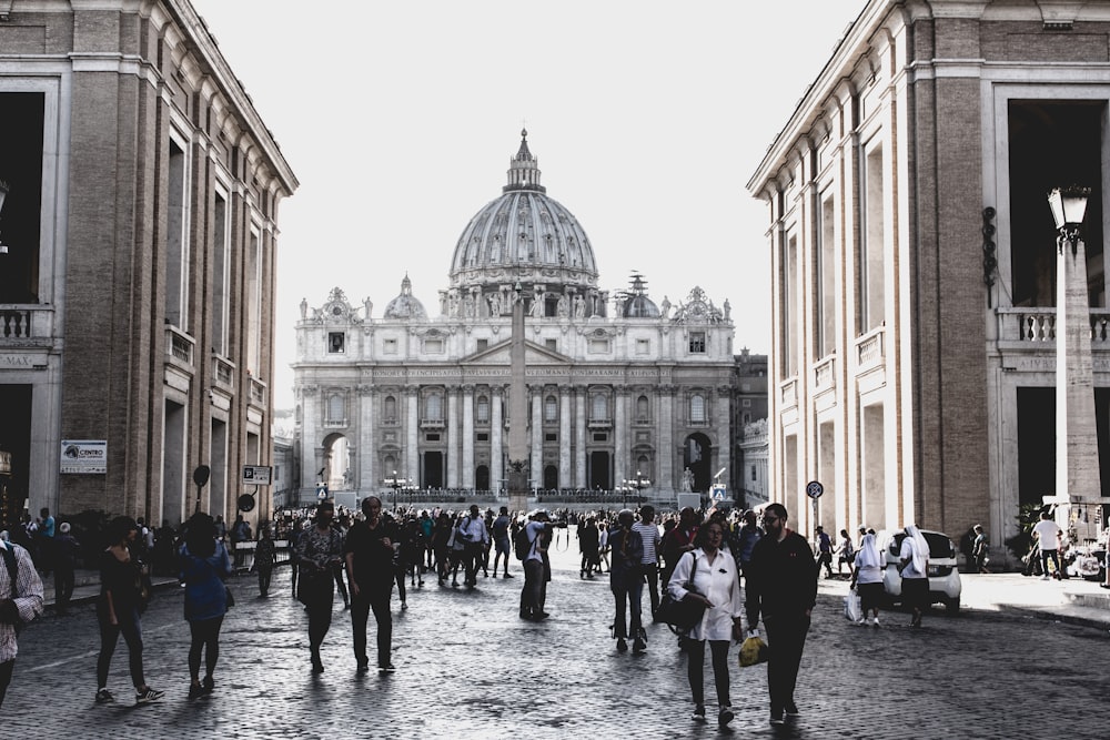 grayscale photography of people walking front of building