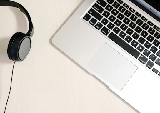 A cozy workspace with headphones placed beside a laptop open on a sonatavibe support page.