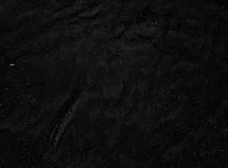 a black and white photo of water and sand