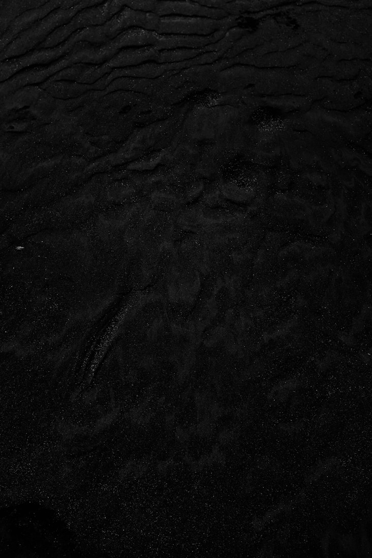 a black and white photo of water and sand