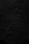 a black and white photo of water and sand