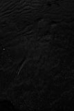 a black and white photo of water and sand
