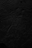 a black and white photo of water and sand