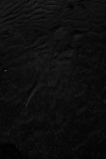 a black and white photo of water and sand