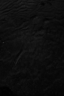 a black and white photo of water and sand