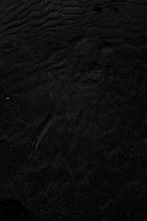 a black and white photo of water and sand