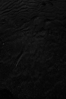 a black and white photo of water and sand