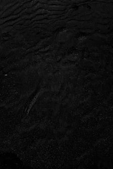 a black and white photo of water and sand