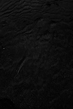 a black and white photo of water and sand