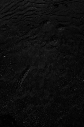 a black and white photo of water and sand