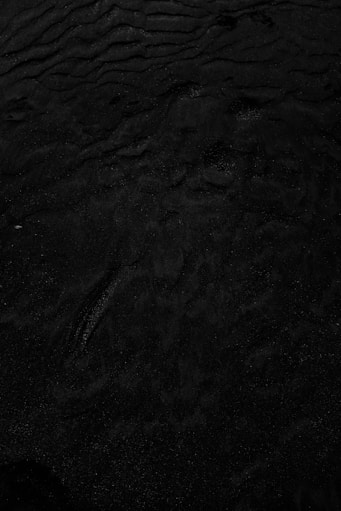 a black and white photo of water and sand