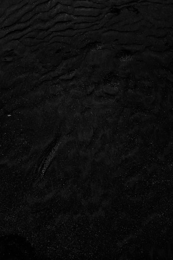 a black and white photo of water and sand