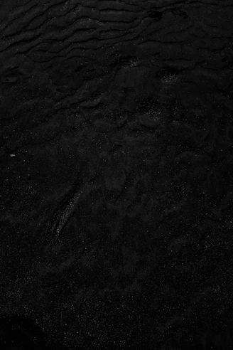 a black and white photo of water and sand