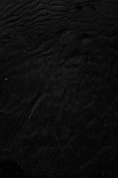 a black and white photo of water and sand