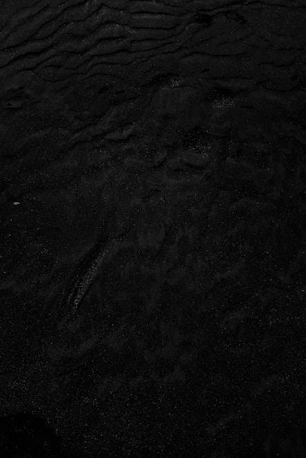 a black and white photo of water and sand