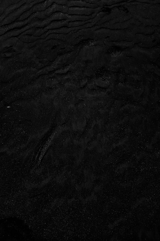 a black and white photo of water and sand