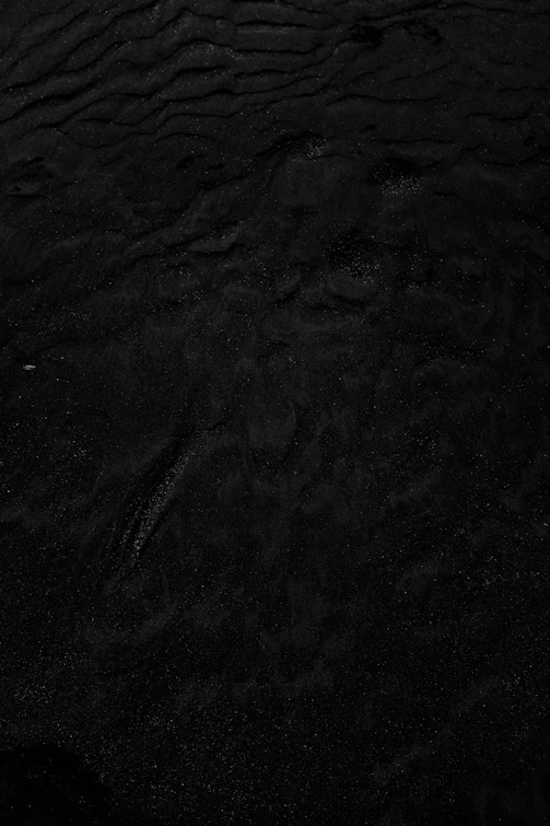 a black and white photo of water and sand