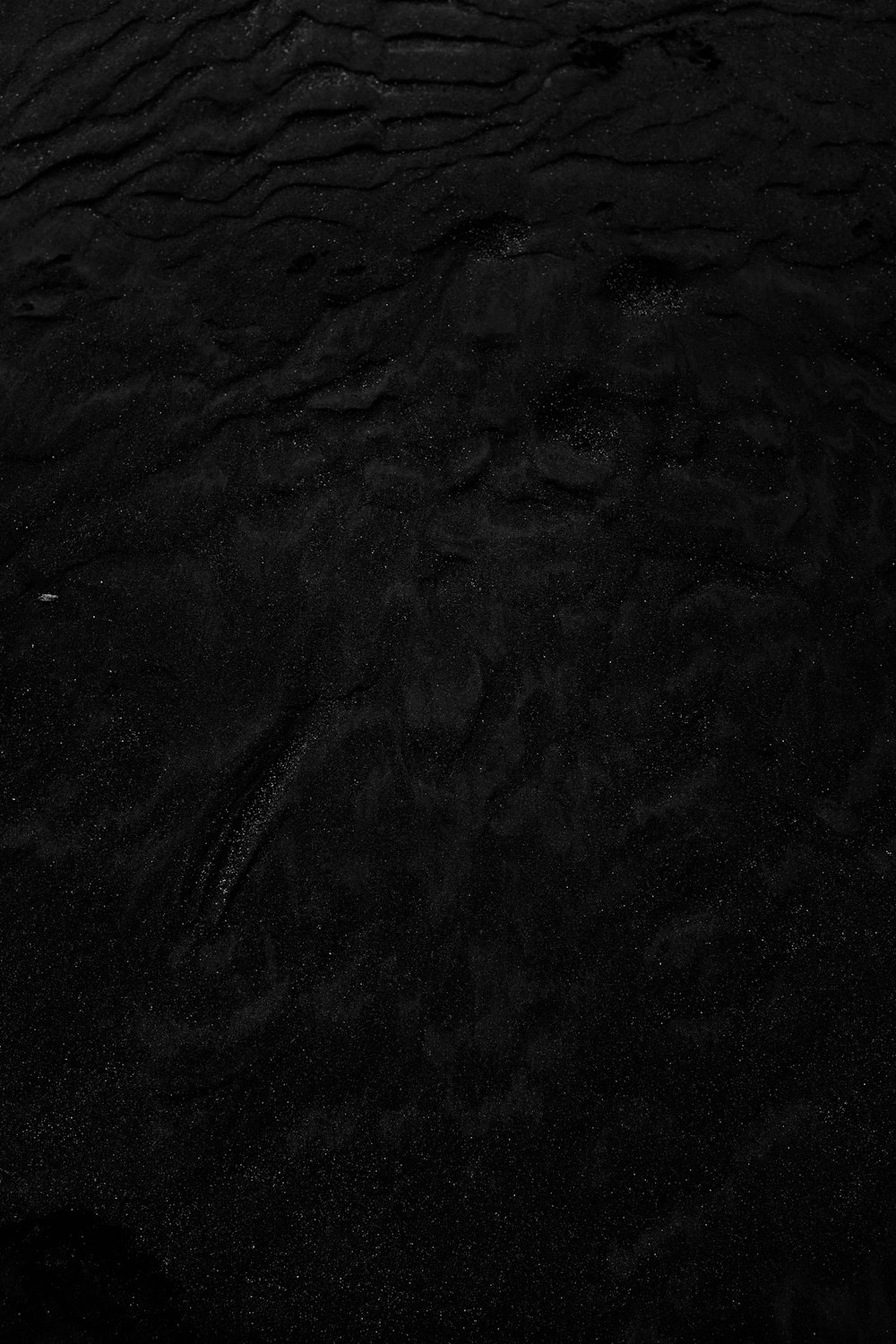 une photo en noir et blanc d’eau et de sable