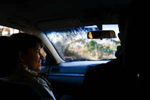 A driver greeting a smiling passenger outside a cozy home in Stillwater, Minnesota.