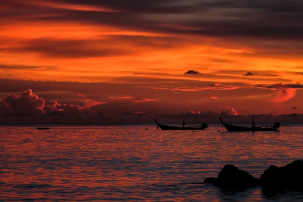 Sunset view over the Red Sea with silhouetted boats.