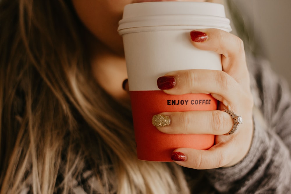 Frau hält eine Tasse Kaffee in der Hand