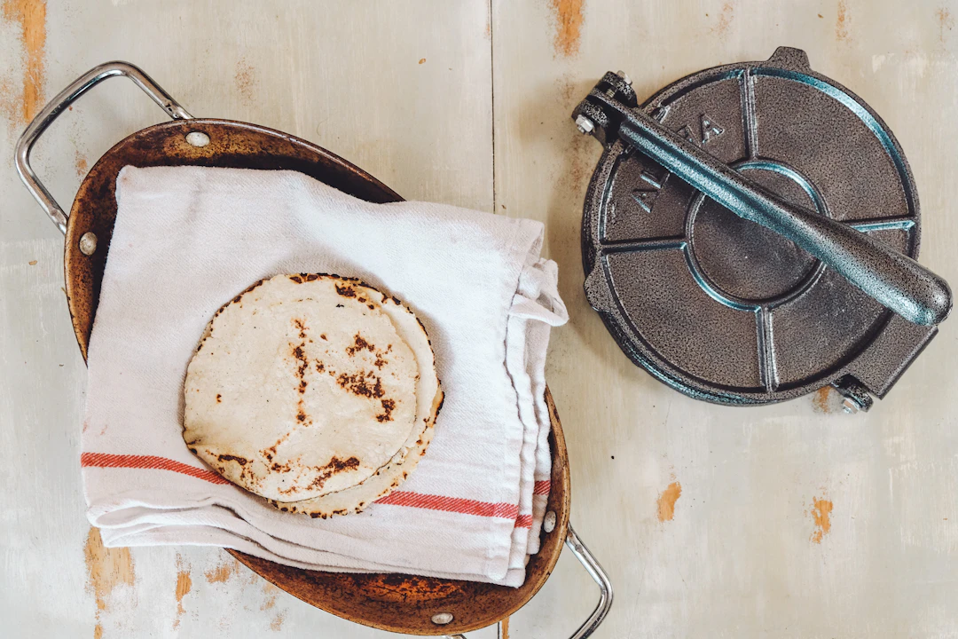 Hand-pressing fresh tortillas on a hot comal.
