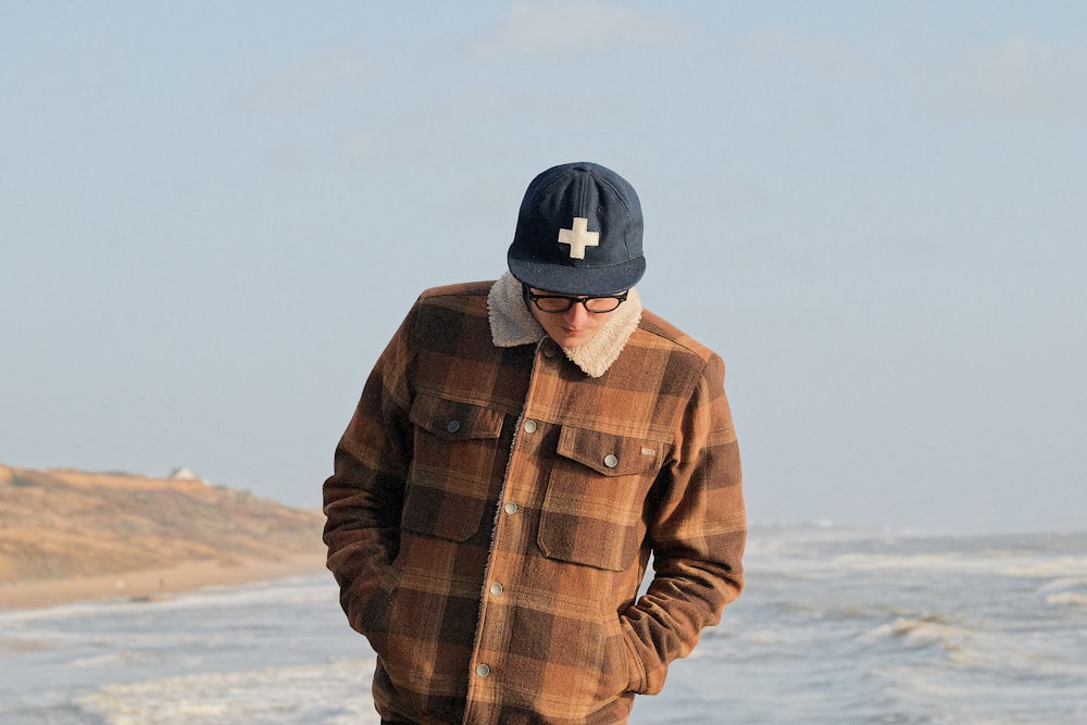 man wearing brown button-up jacket looking down