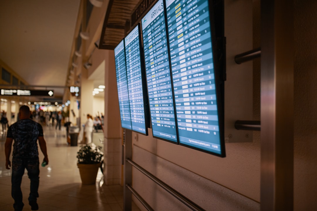 man walking on pathway near flat screen TV